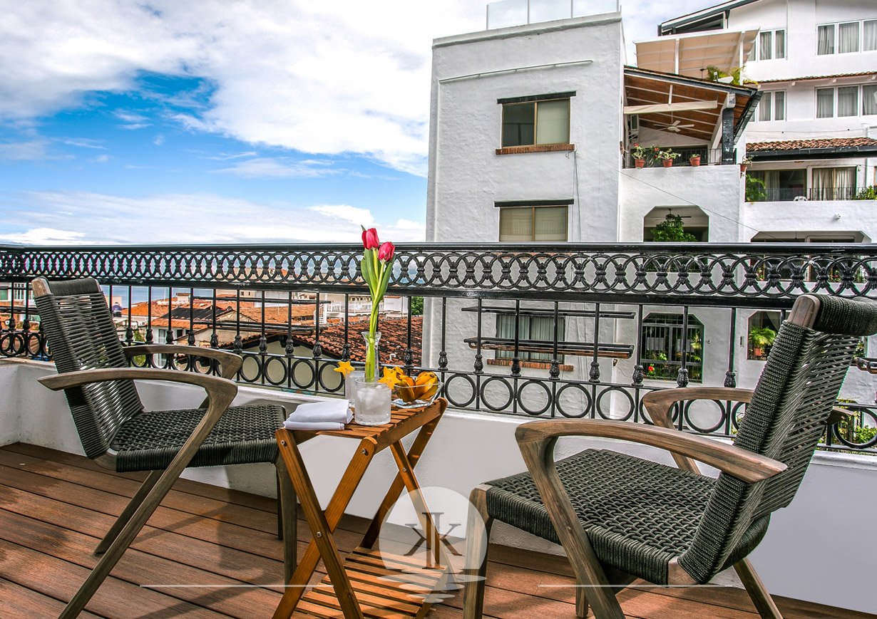 Balcony with comfortable seating and views of the ocean.